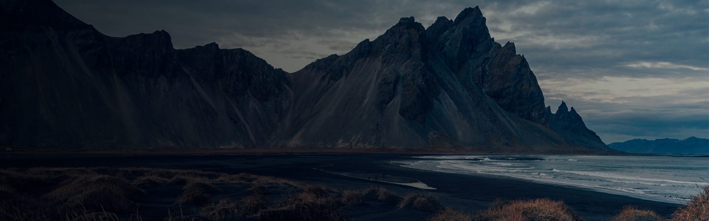 Paisaje con fondo de montañas y parte de un lago